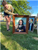 mona lisa painting with face cutout with a child looking through