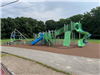 a large green playground with blue slides