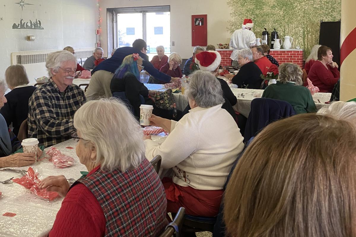 Tables full of people for the Christmas Party.