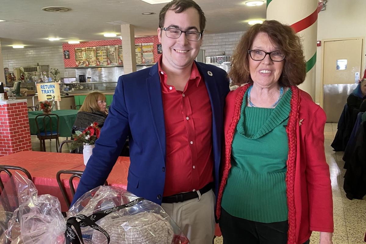 Two people smiling at the Holiday Party.