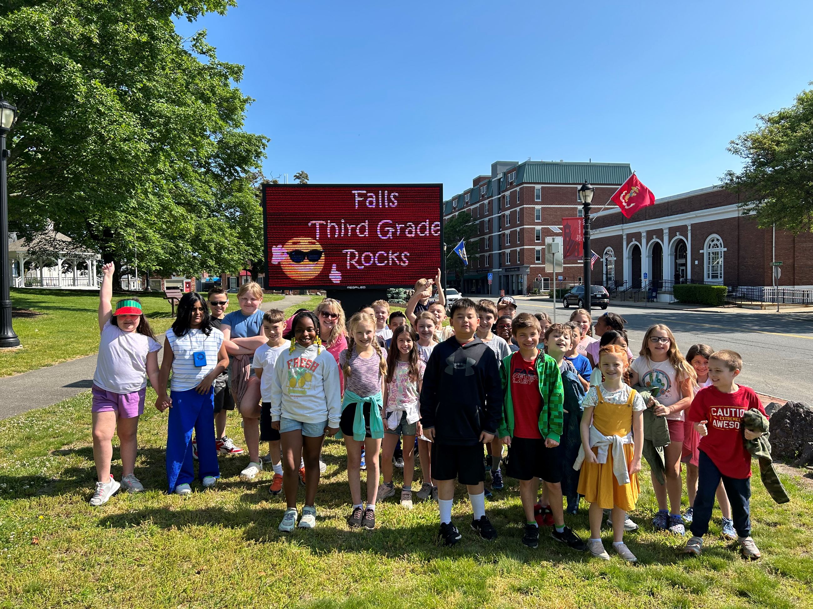 Falls school kids in front of digital sign