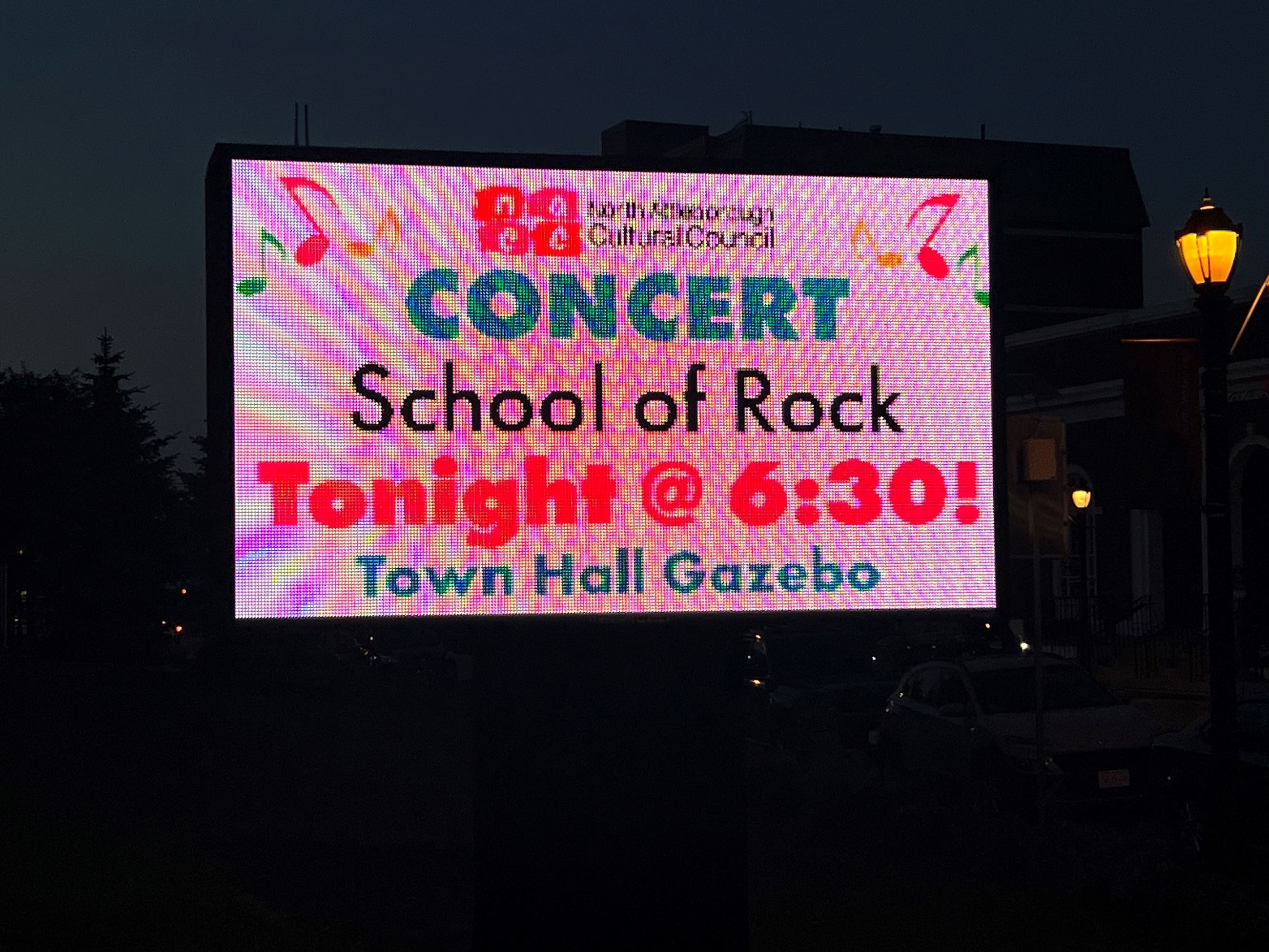 the digital sign in front of town hall promoting the School of Rock concert