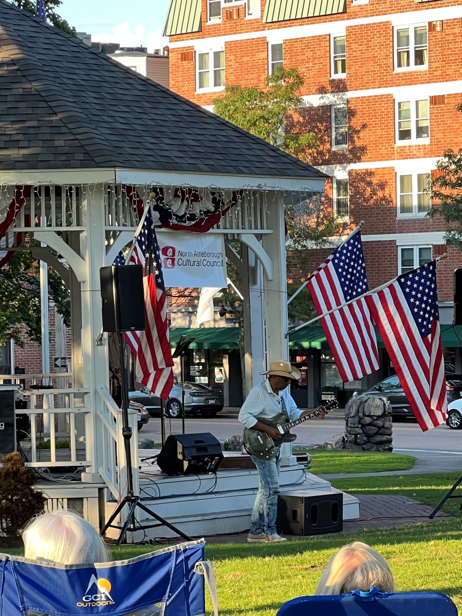 Willie J Laws playing a guitar in front of the gazebo