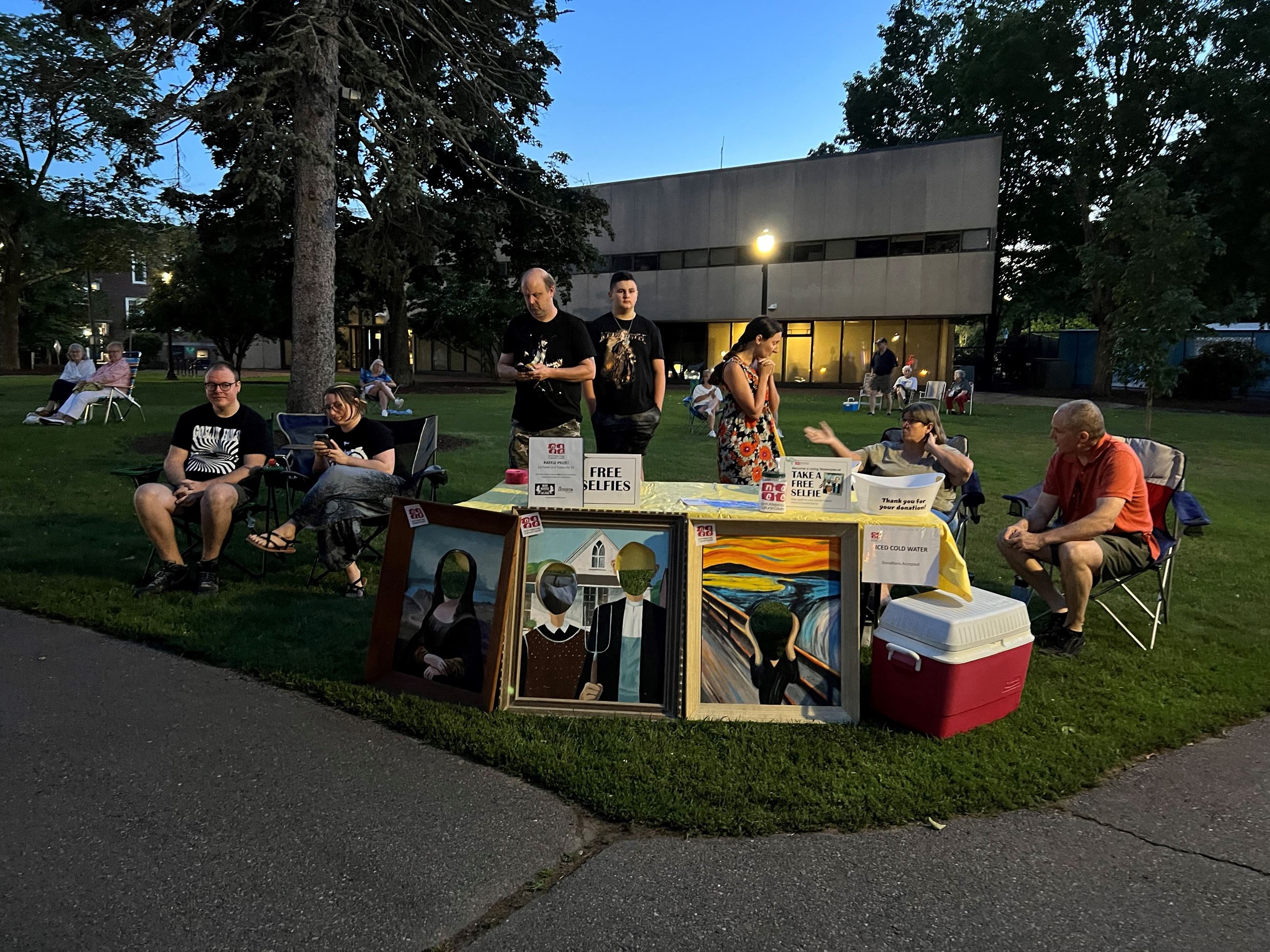 the north attleboro cultural council's table at the concert with three cutout paintings