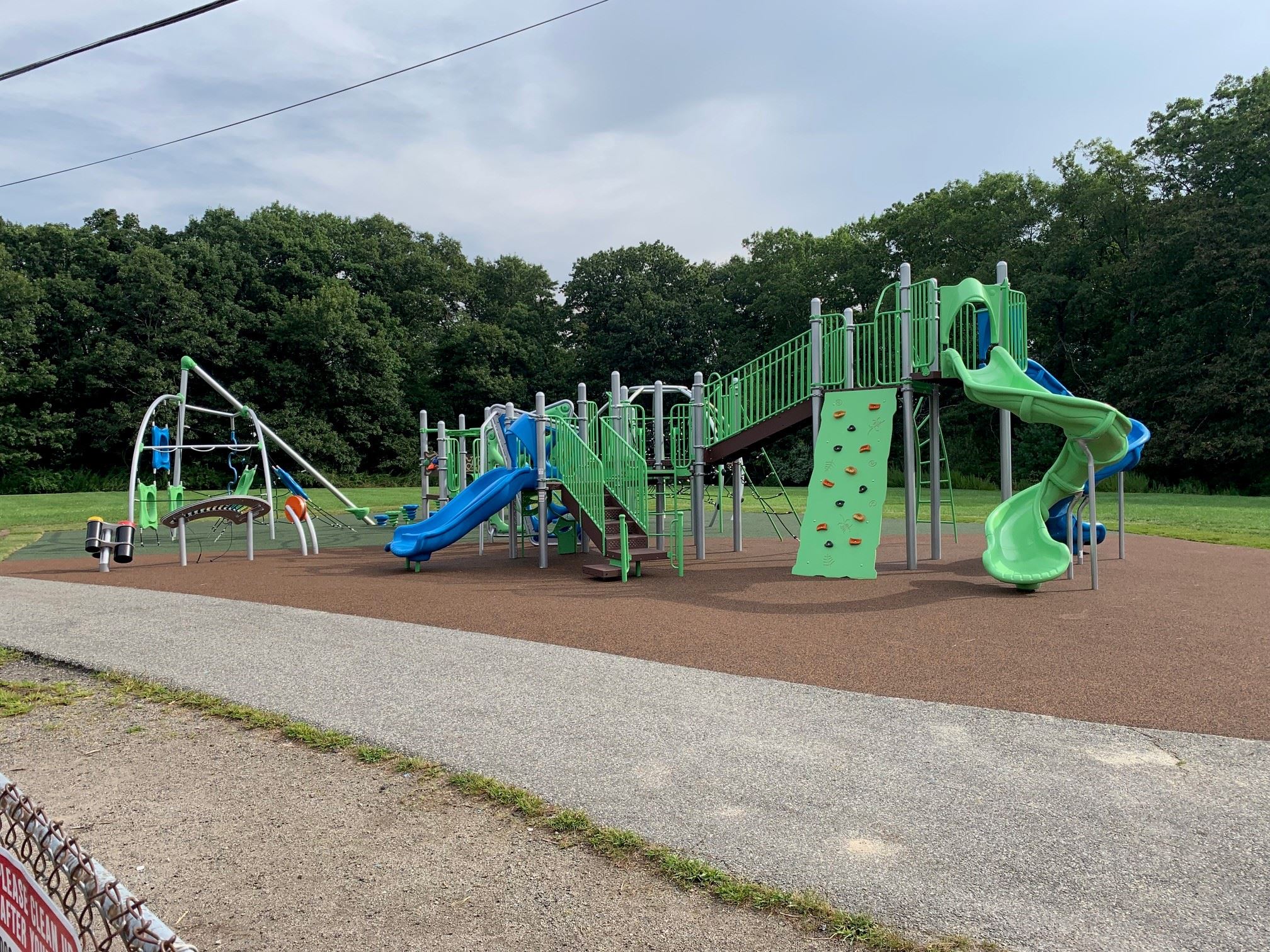 a large green playground with blue slides